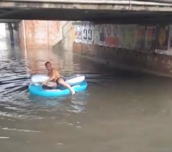 Il maltempo non frena un turista: bagno col canotto nel sottopasso allagato dopo il temporale - VIDEO